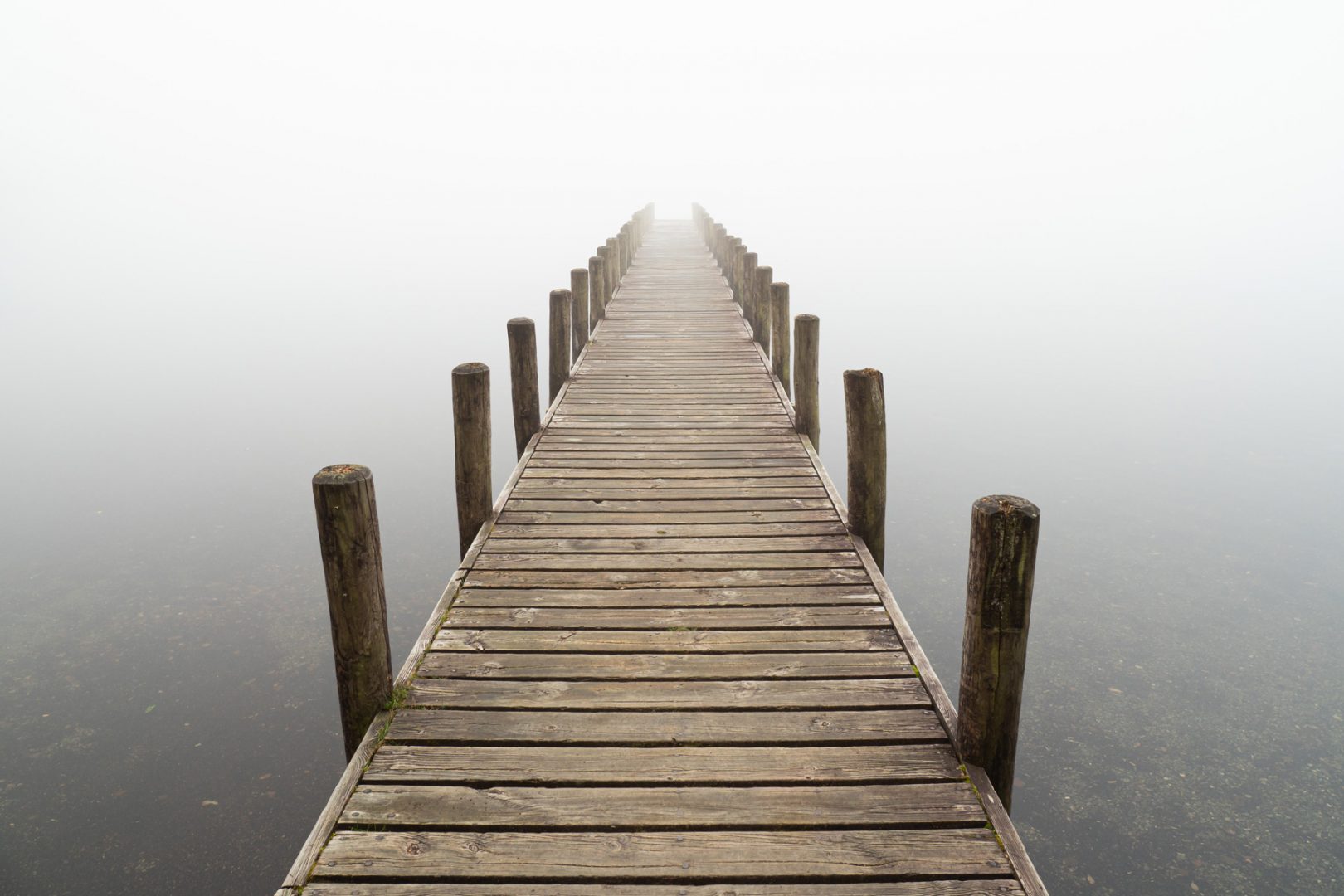 Steg auf stark nebeligem See